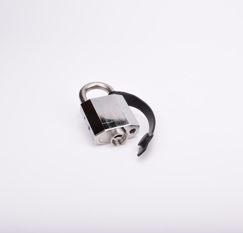 Silverfärgat hänglås med rektangulär kropp och rund bygel. En svart gummirem hänger från hänglåsets bygel.