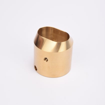 Cylindrisk mässingslås med runt sidohål och avfasad topp med oregelbunden öppning.