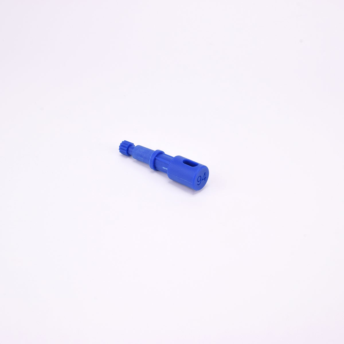 Blå användarpegg med cylindrisk form och flera sektioner med olika diameter. Ena änden är ihålig med ett avlångt spår, medan den motsatta änden har en räfflad yta.
