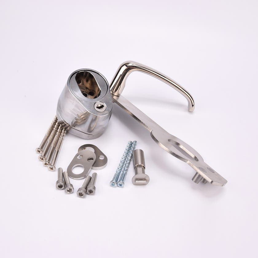 Ett dörrhandtag i metall fäst på en rektangulär metallplatta med tillhörande låscylinder och flera olika skruvar och beslag.