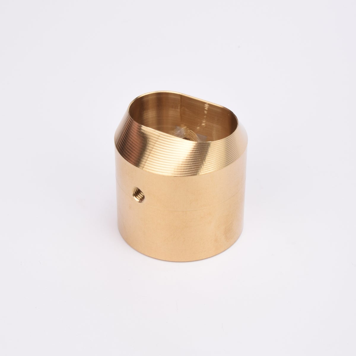 Cylindrisk mässingslås med runt sidohål och avfasad topp med oregelbunden öppning.