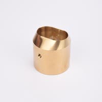 Cylindrisk mässingslås med runt sidohål och avfasad topp med oregelbunden öppning.