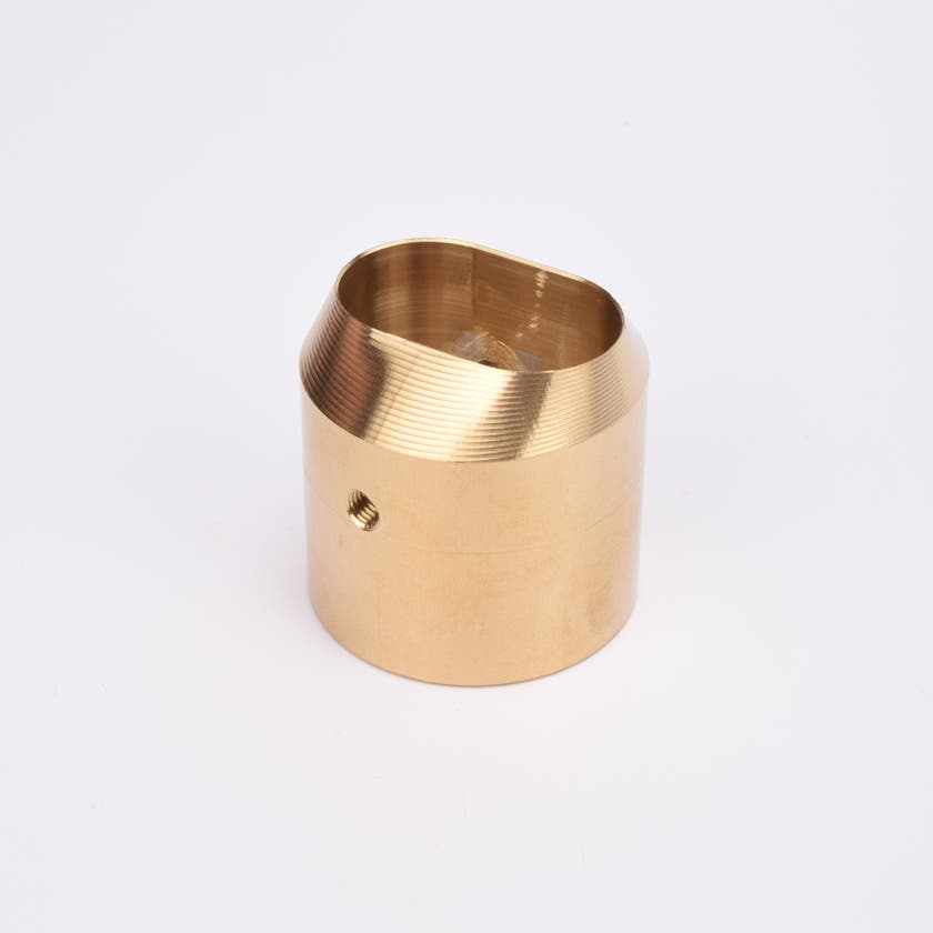 Cylindrisk mässingslås med runt sidohål och avfasad topp med oregelbunden öppning.