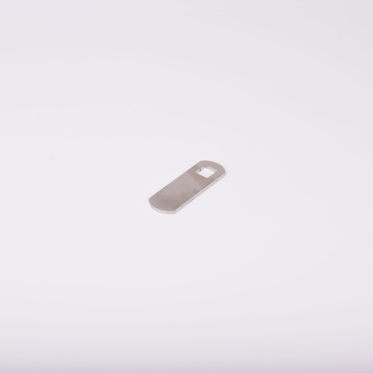 Låsrigel i metall med fyrkantigt hål i ena änden.