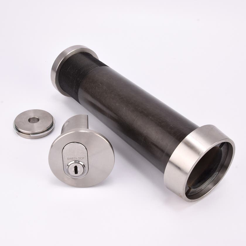 Cylindrisk nyckelfacksrör med svart kropp och silverfärgade ändar, samt ett runt lås och en rund bricka.