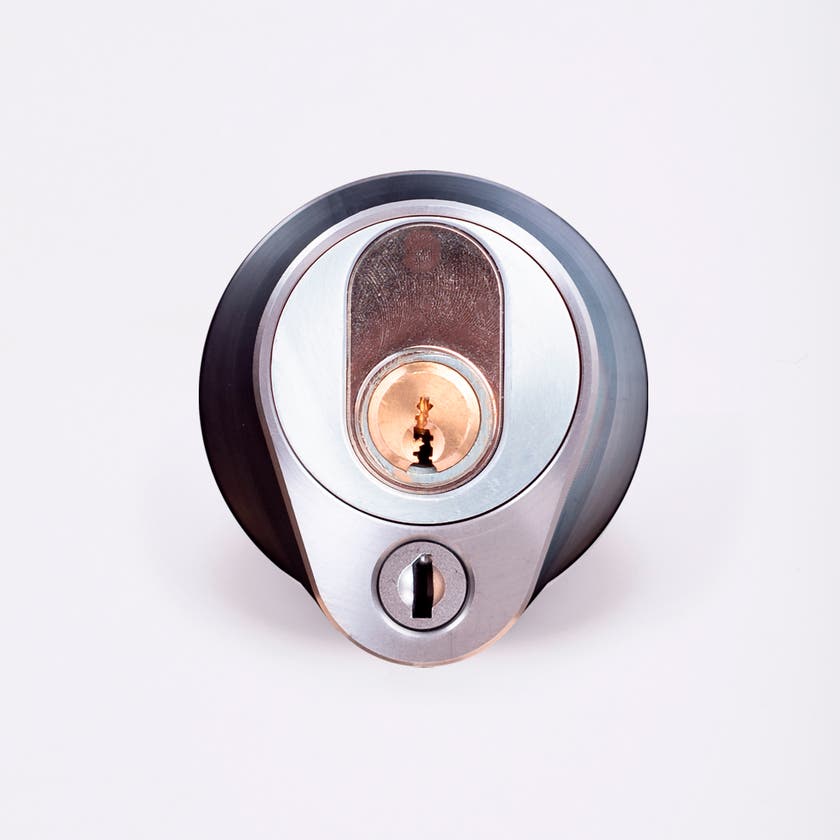 Närbild av ett silverfärgat säkerhetslås med två nyckelhål, placerade ovanför varandra.