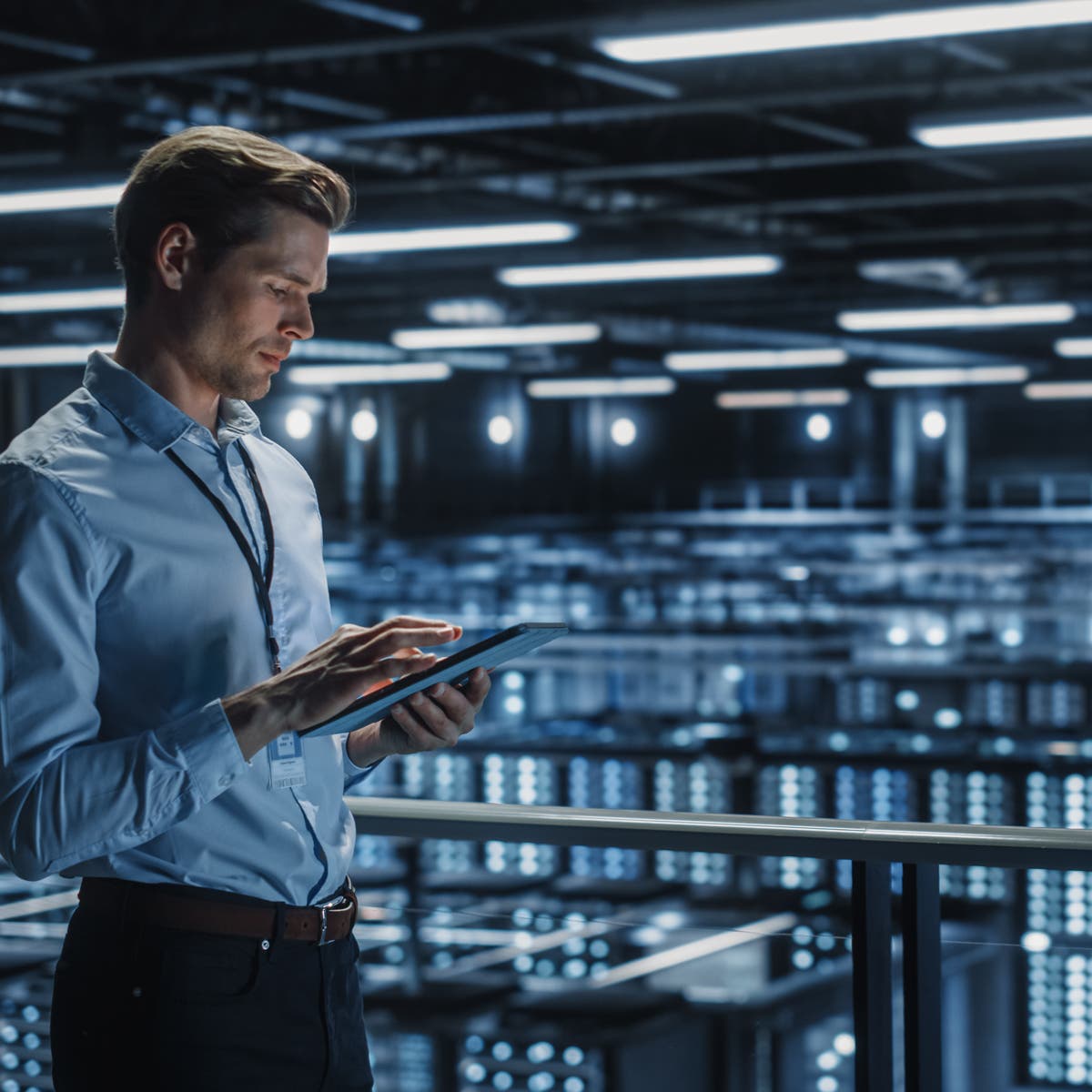 En mann som står i et rom med et nettbrett i hånden og håndterer nøkler og tilgang digitalt