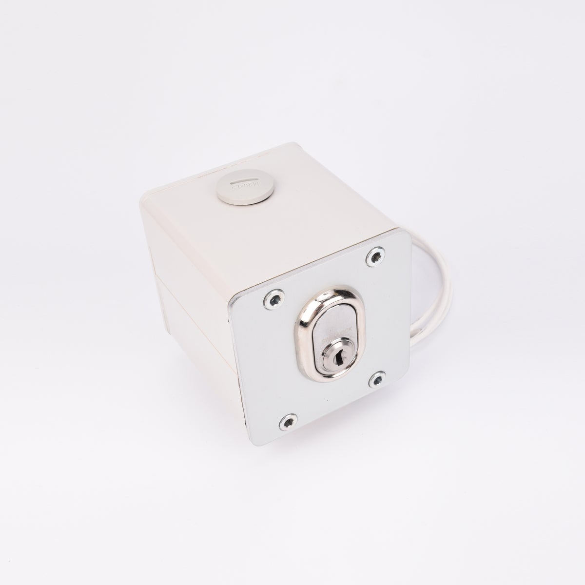 Vit fyrkantig elektrisk nyckelbrytare med metallisk låscylinder, rund knapp upptill, fyra hörnskruvar och kabelutgång på sidan.