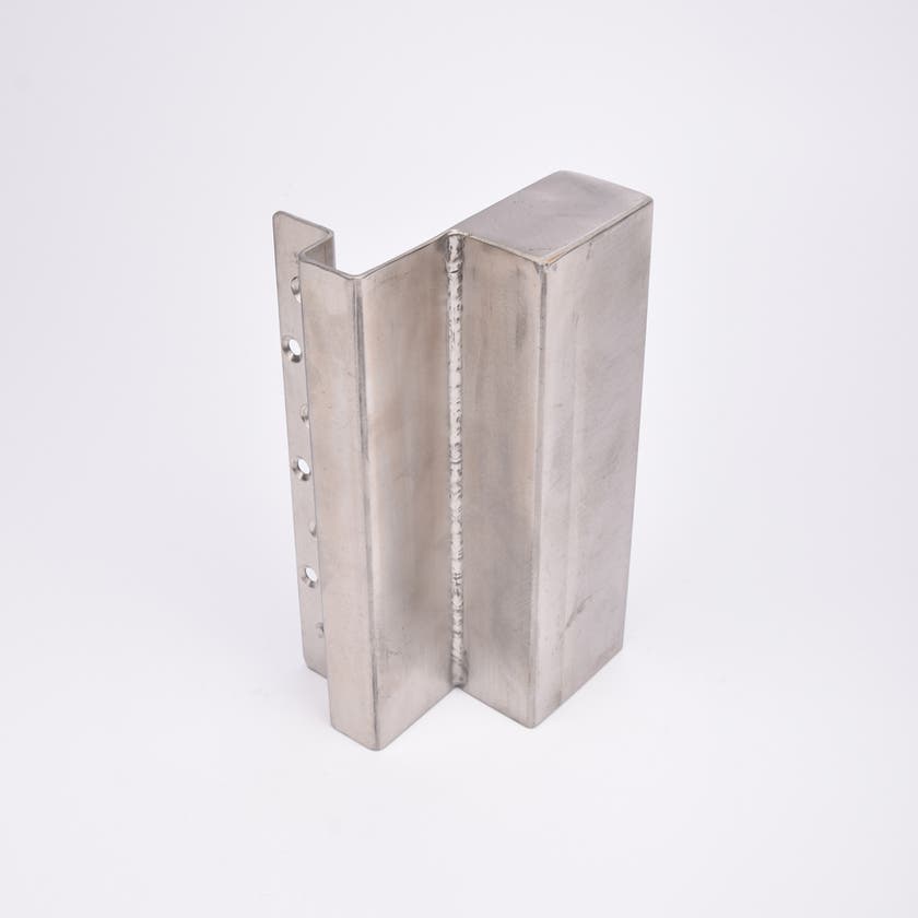 En L-formad nyckelförvaringsenhet med flera cirkulära hål längs ena sidan.