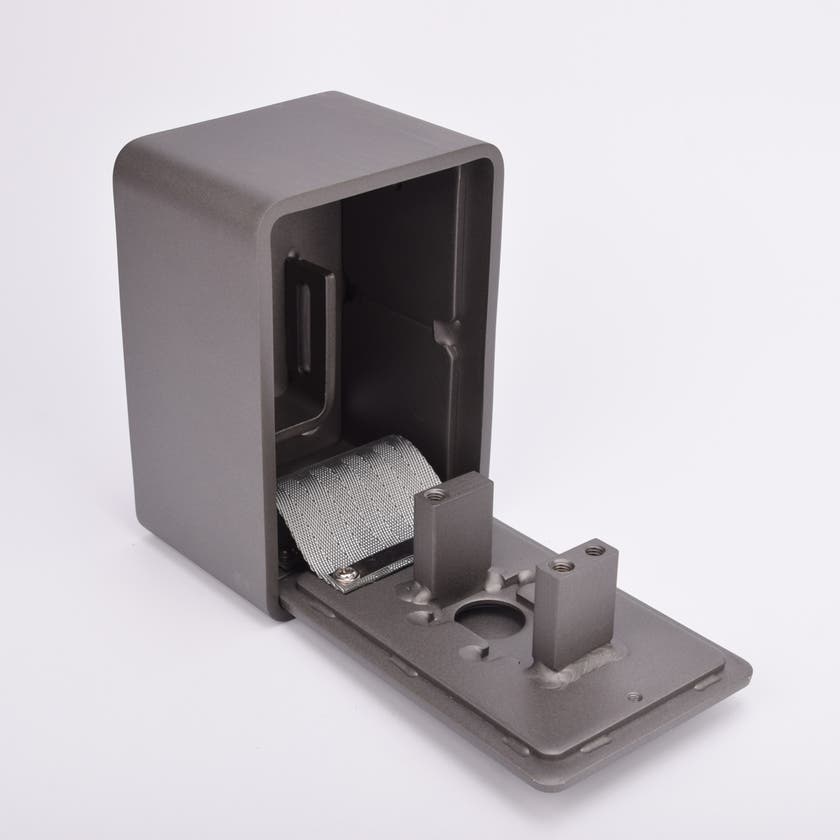 Grått fasadnyckelskåp i metall med rundade hörn och helt utfälld lucka.