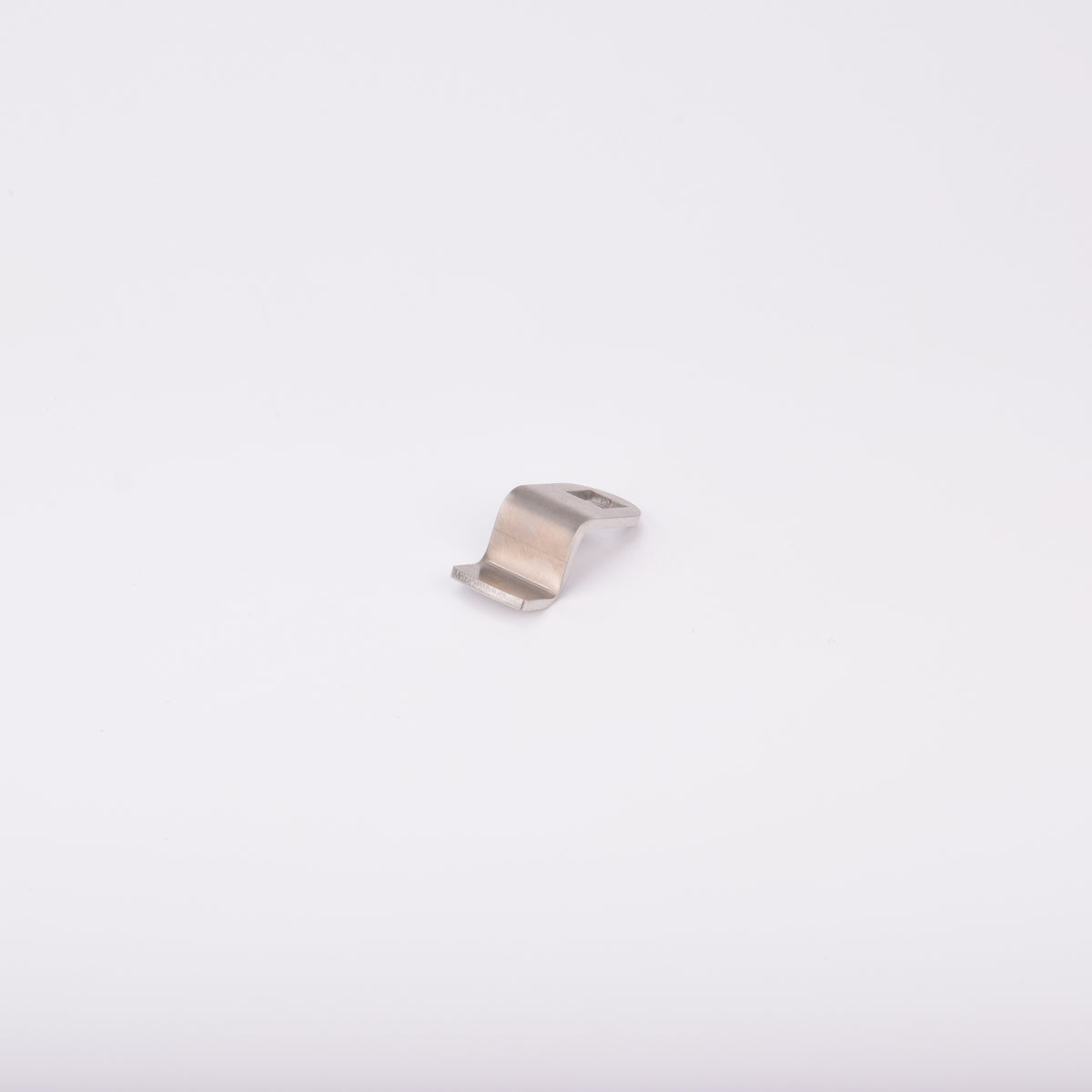 Låsrigel i metall med vågformad design och ett hål i ena änden.