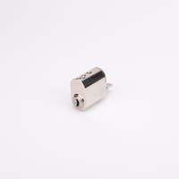 Oval låscylinder i silverfärgad metall med en kort, platt, räfflad metall medbringare.