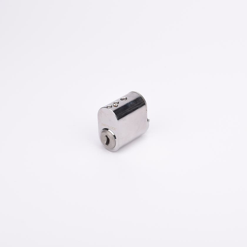 Liten cylindrisk låskolv i metall med blank yta.