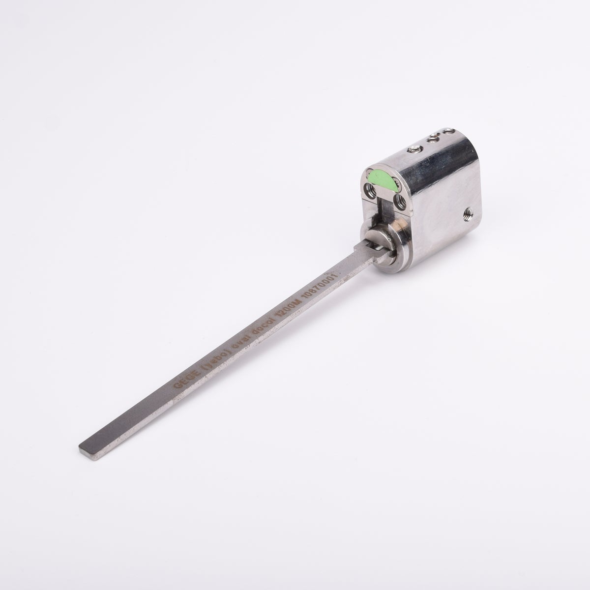 Oval låscylinder i silverfärgad metall med en lång, platt, räfflad metall medbringare.