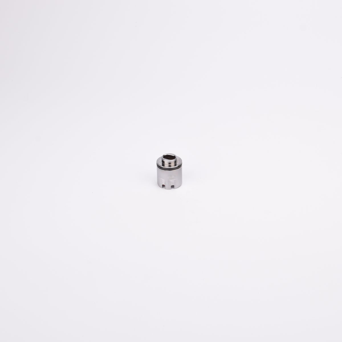 Cylindrisk adapterhylsa med svart gummitätning nära toppen samt avsmalnande topp med ett hål i.