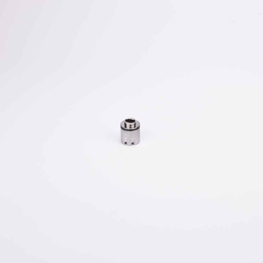 Cylindrisk adapterhylsa med svart gummitätning nära toppen samt avsmalnande topp med ett hål i.