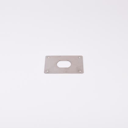 En rektangulär metallplatta med hål i mitten.