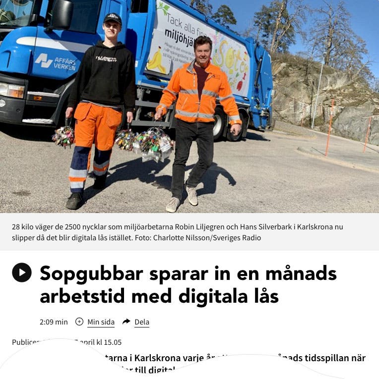 Två personer klädda i orange hållandes stora nyckelknippor framför en sopbil