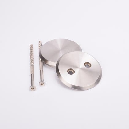 Två rostfria skruvar och två runda täcklocksbrickor i metall med två runda hål.