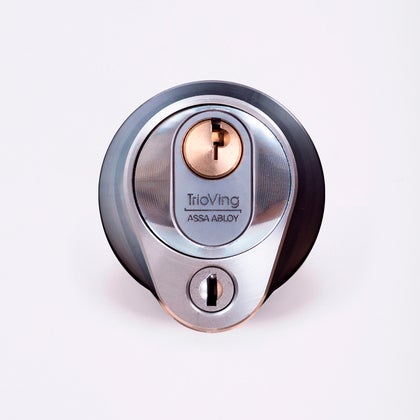 Närbild av ett silverfärgat säkerhetslås med två nyckelhål, placerade ovanför varandra.