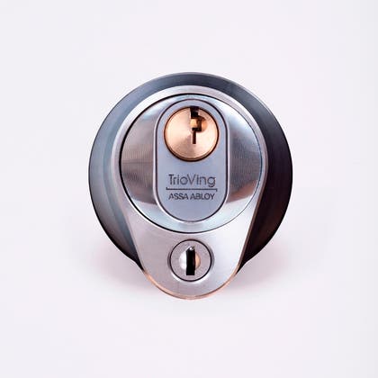 Närbild av ett silverfärgat säkerhetslås med två nyckelhål, placerade ovanför varandra.