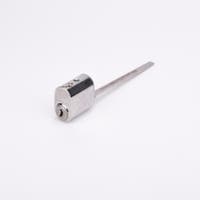 Oval låscylinder i silverfärgad metall med en lång, platt, räfflad metall medbringare.