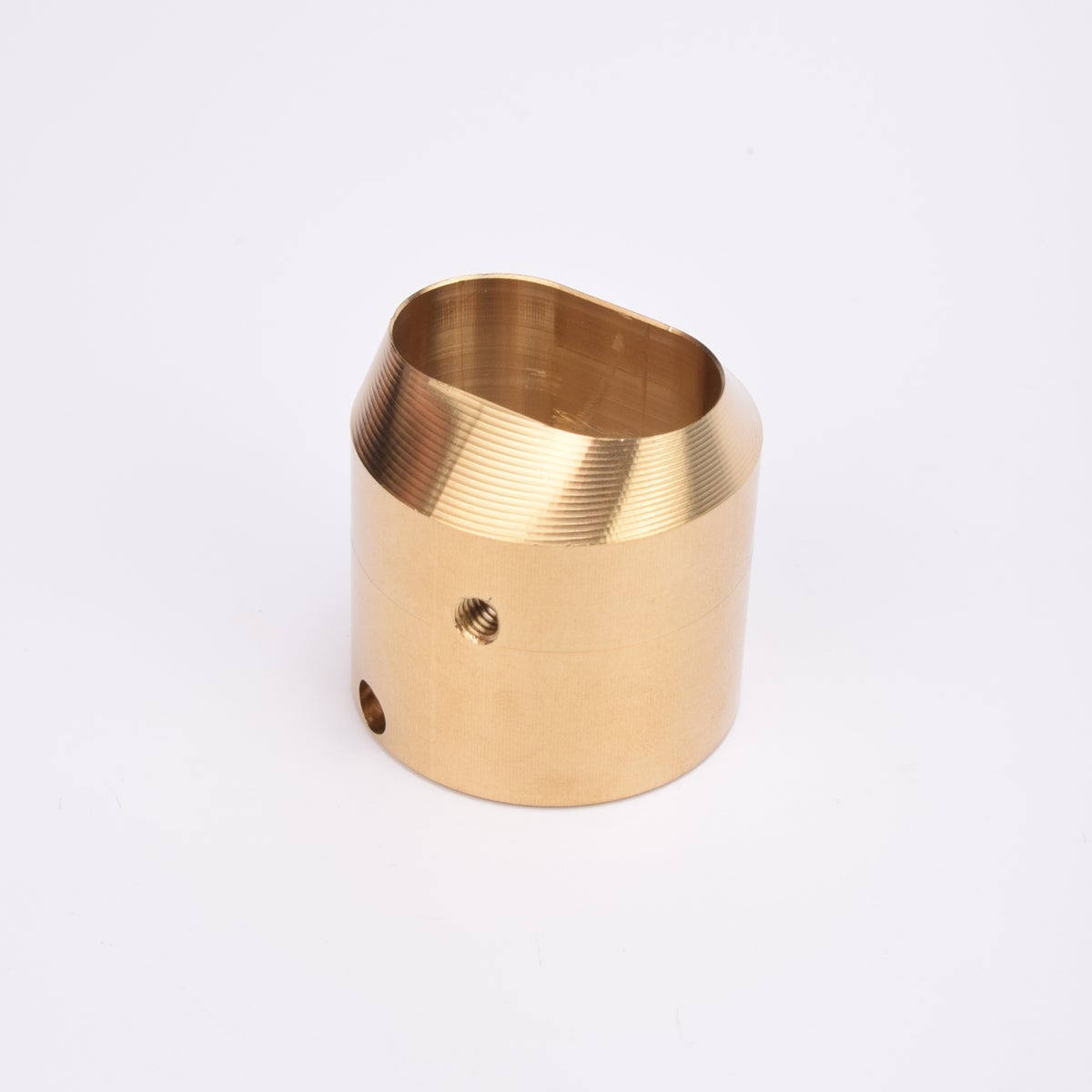 Cylindrisk mässingslås med runt sidohål och avfasad topp med oregelbunden öppning.