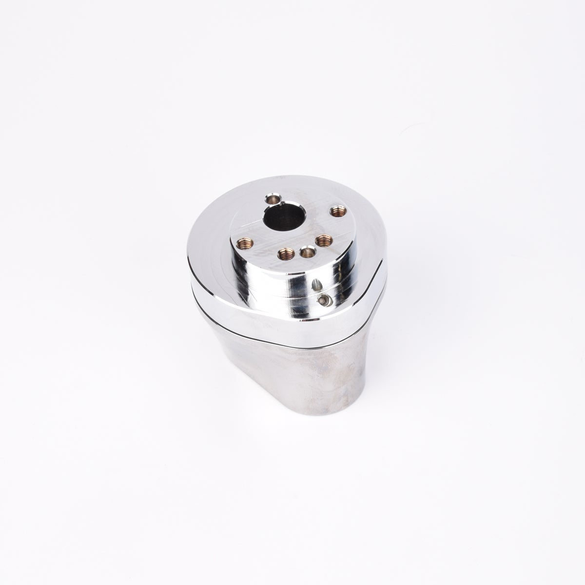 Silverfärgad metallkropp med rundad bas och flera hål på ovansidan.