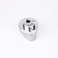 Silverfärgad metallkropp med rundad bas och flera hål på ovansidan.