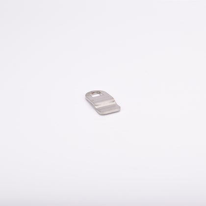 Liten rigel i metall med rektangulärt urtag nära ena änden, lätt böjd form.