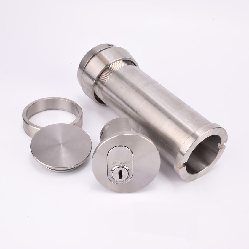 Cylindrisk silverfärgat nyckelfacksrör samt ett runt lås, en rund bricka och en rund ring.