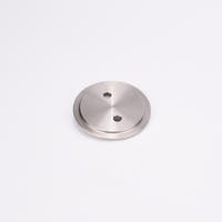 Metallisk, cirkulärt täcklock med slät, reflekterande yta och två jämnt placerade hål nära mitten.