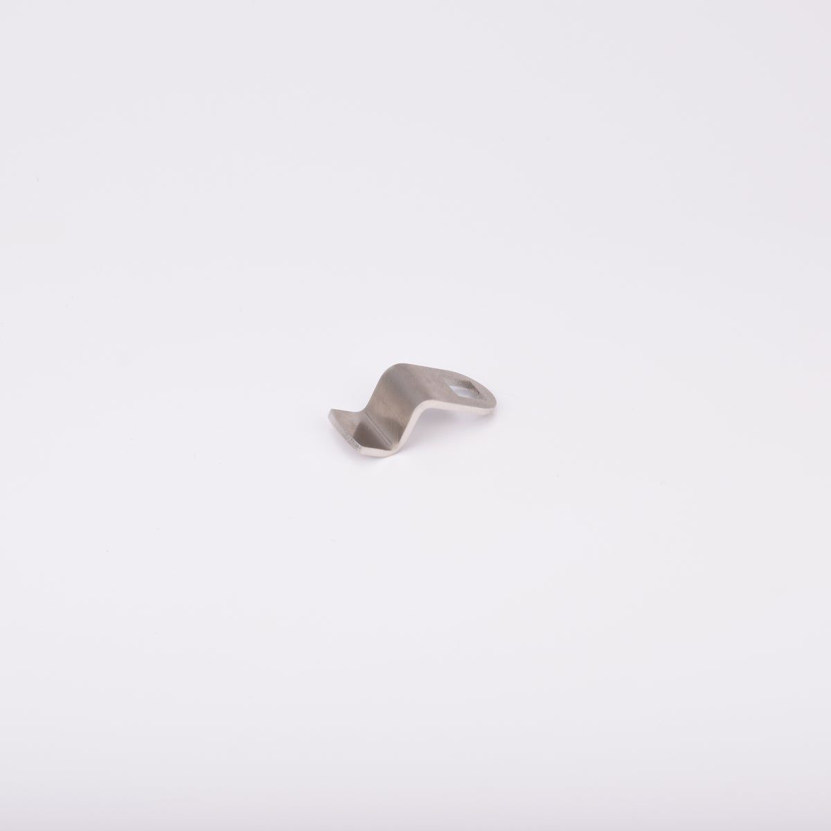 Låsrigel i metall med vågformad design och ett hål i ena änden.