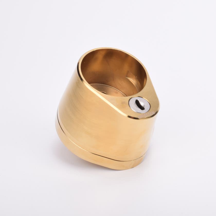 Droppformat mässingslås med rundformat urtag för låscylinder, samt nyckelhål i nedre delen.