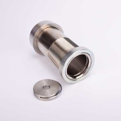 Cylindrisk silverfärgat nyckelfacksrör samt ett runt lås och en rund bricka.