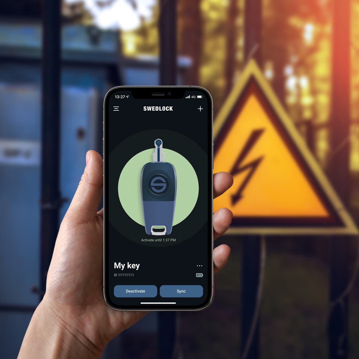 En hånd som holder en mobiltelefon der en Swedlock-nøkkel får tilgang