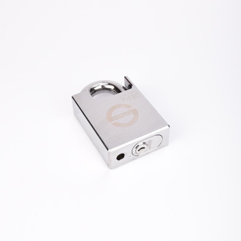 Silverfärgat hänglås med rektangulär kropp och rund bygel.