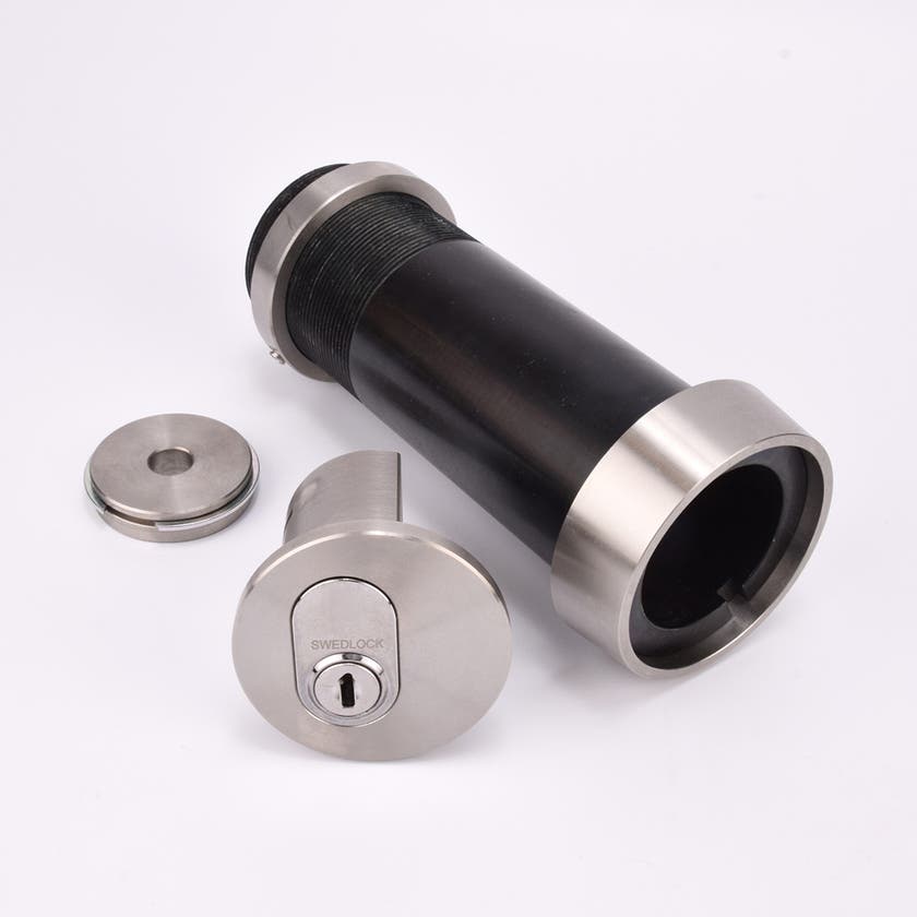 Cylindrisk nyckelfacksrör med svart kropp och silverfärgade ändar, samt ett runt lås och en rund bricka.