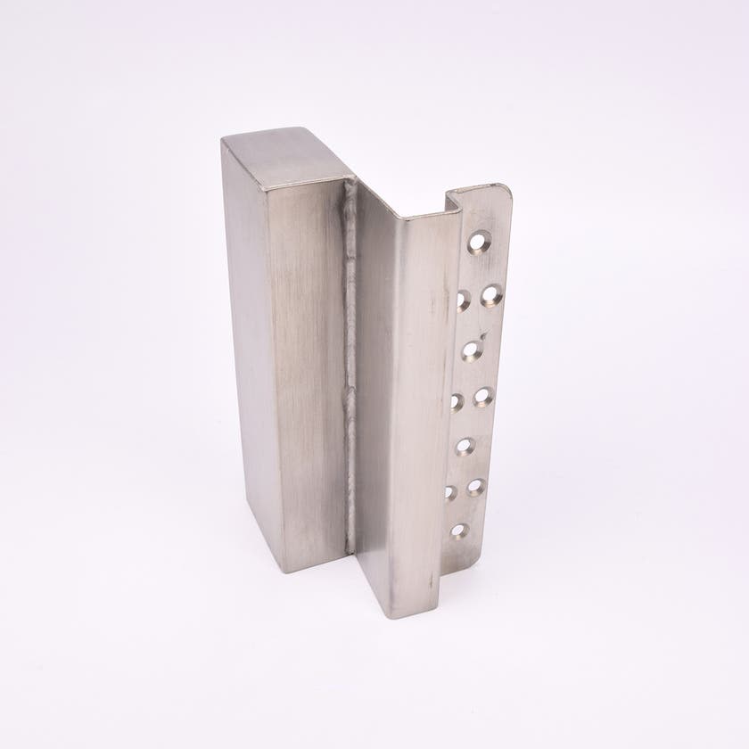 En L-formad nyckelförvaringsenhet med flera cirkulära hål längs ena sidan.