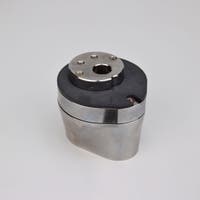 Silverfärgad metallkropp med rundad bas och flera hål på ovansidan.