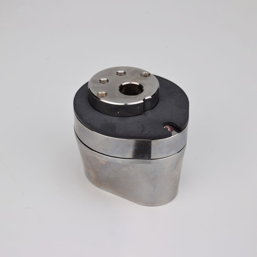 Silverfärgad metallkropp med rundad bas och flera hål på ovansidan.