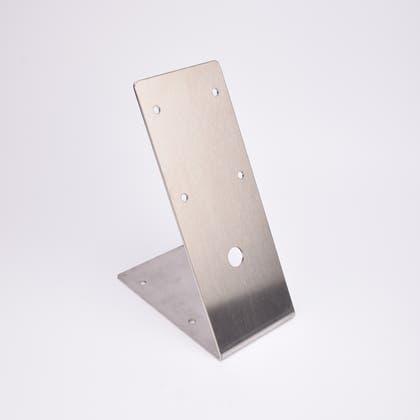 L-formad metallplatta med fem små hål och ett större centralt hål.