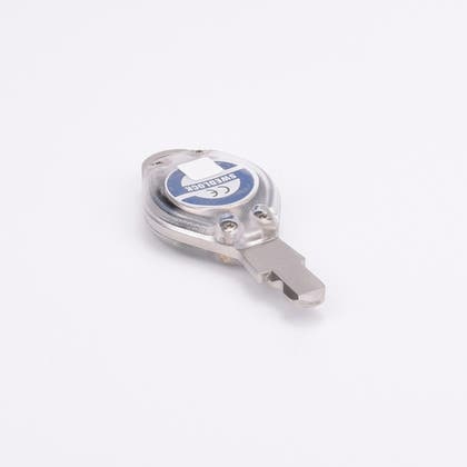 Närbild av metallnyckeln Blue med genomskinligt plasthölje och etikett med texten "SWEDLOCK" och CE-märkning.