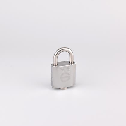 Metallhänglås med rektangulär låskropp och bygel i stål, visat fristående mot ljus bakgrund.