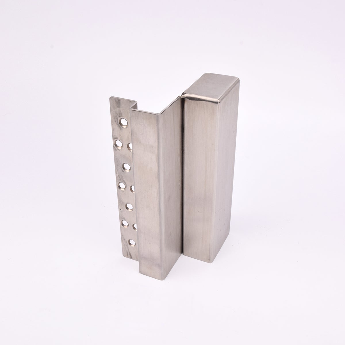 En L-formad nyckelförvaringsenhet med flera cirkulära hål längs ena sidan. 