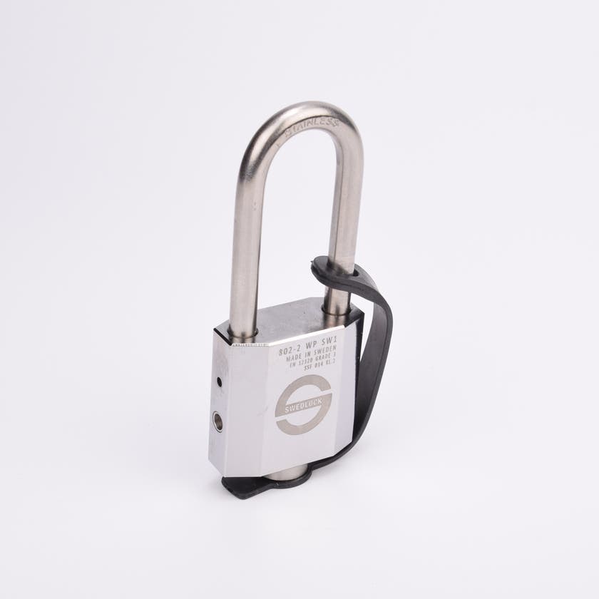 Silverfärgat hänglås med rektangulär kropp och rund bygel. En svart gummirem är fäst från hänglåsets nedre del till bygeln.