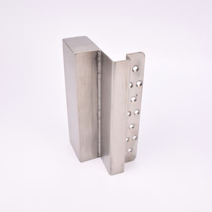 En L-formad nyckelförvaringsenhet med flera cirkulära hål längs ena sidan.