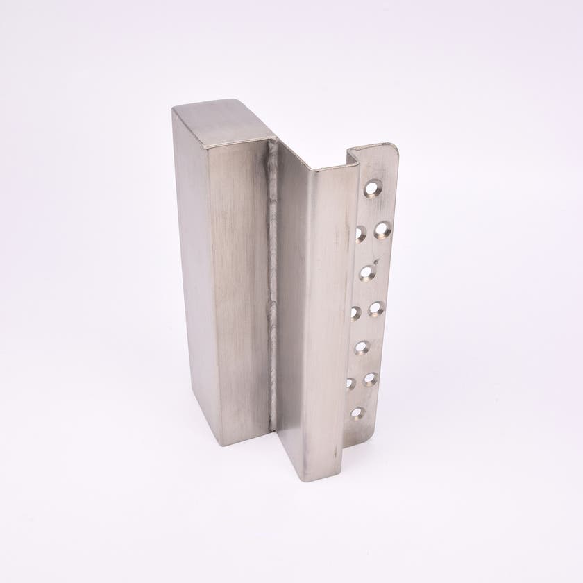 En L-formad nyckelförvaringsenhet med flera cirkulära hål längs ena sidan.