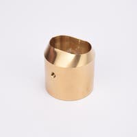 Mässingsfärgat utfyllnadsadapter i metall med snedskuren topp som bildare en oval öppning.