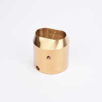 Mässingsfärgat utfyllnadsadapter i metall med snedskuren topp som bildar en oval öppning.